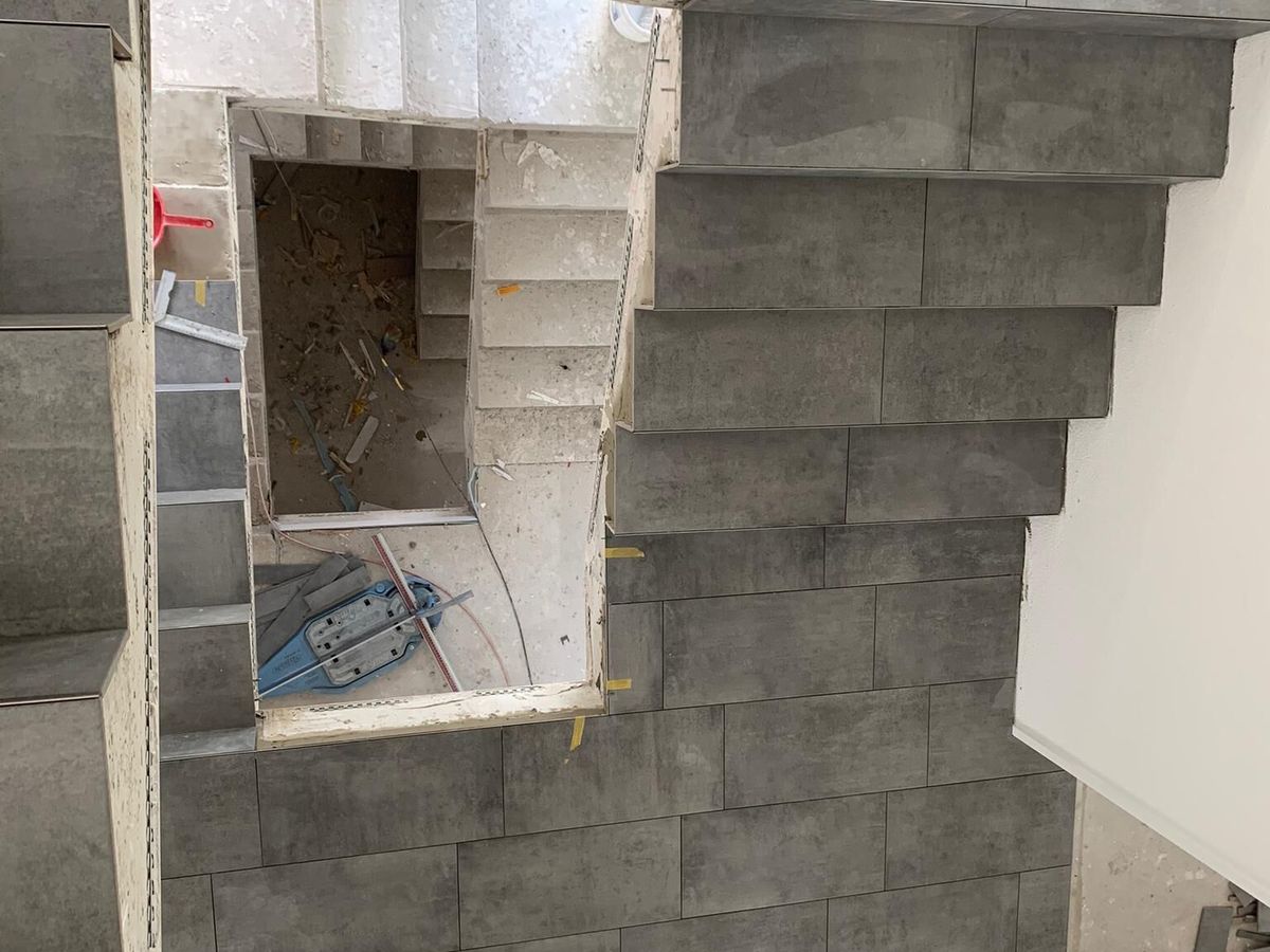 Treppenhaus mit grauen Platten an Stufen und Wänden