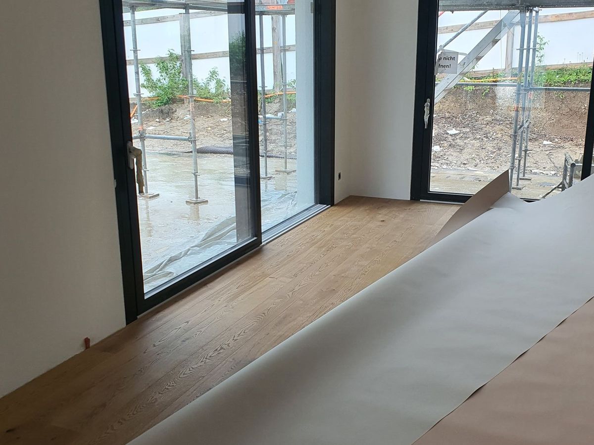 Raum mit neuem Holzboden und grossen Fenstern
